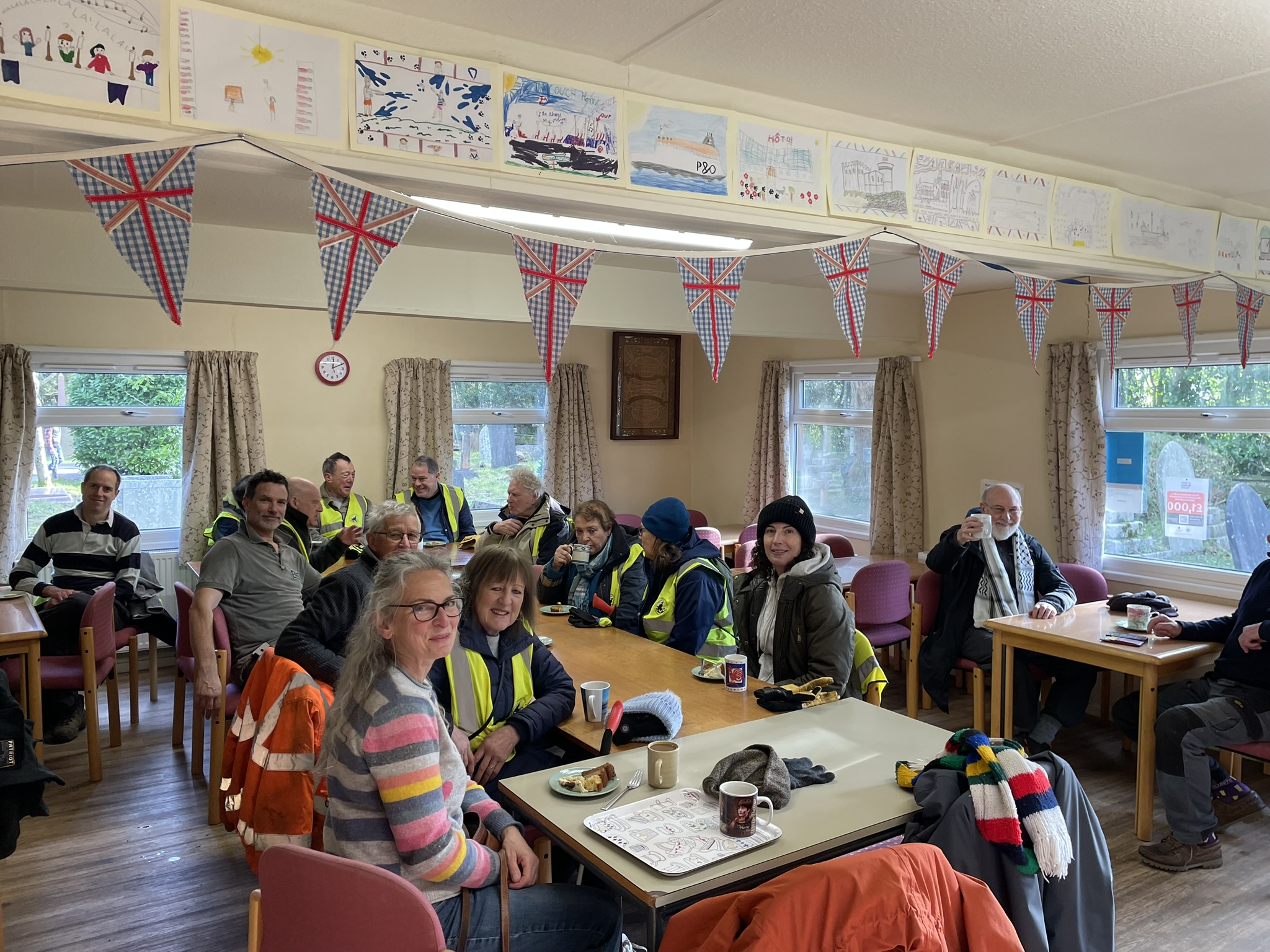 Group of people chatting and drinking hot drinks.